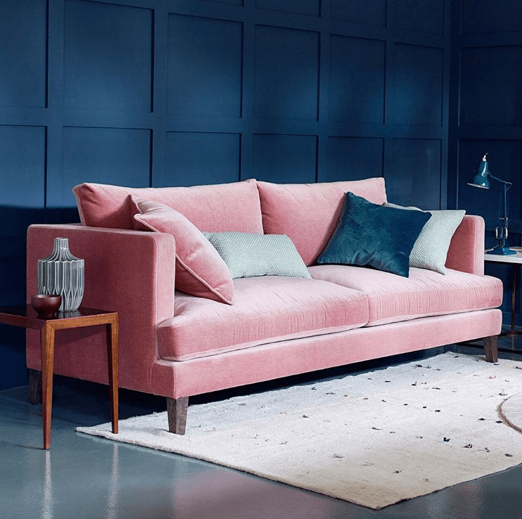 pink  wall and navy blue sofa