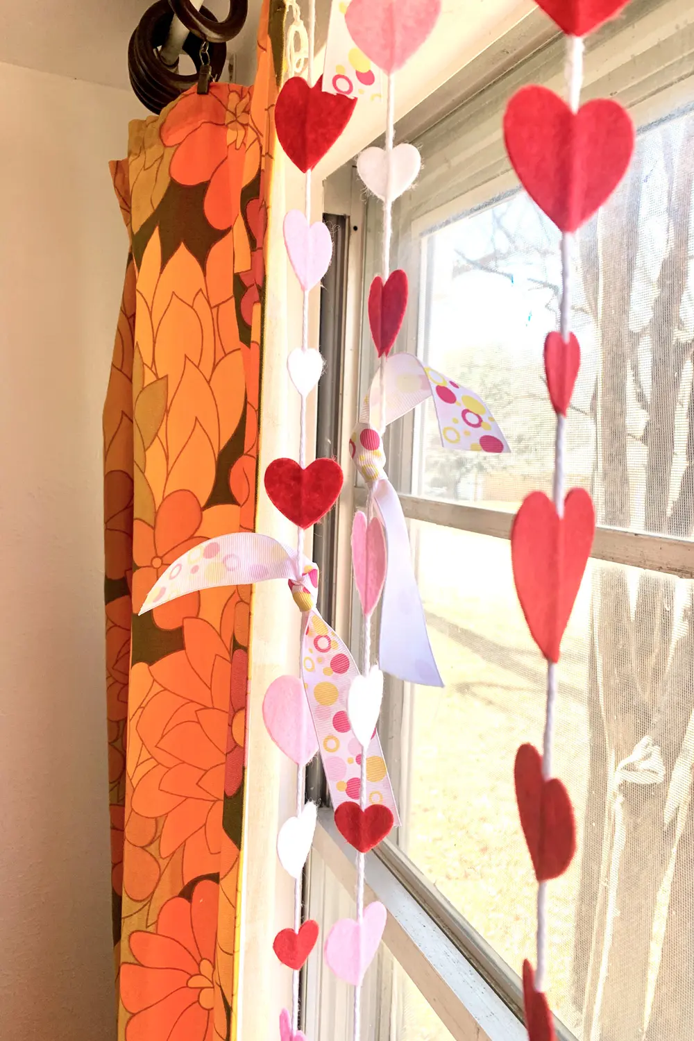 Heart garland hanging across a living room window.